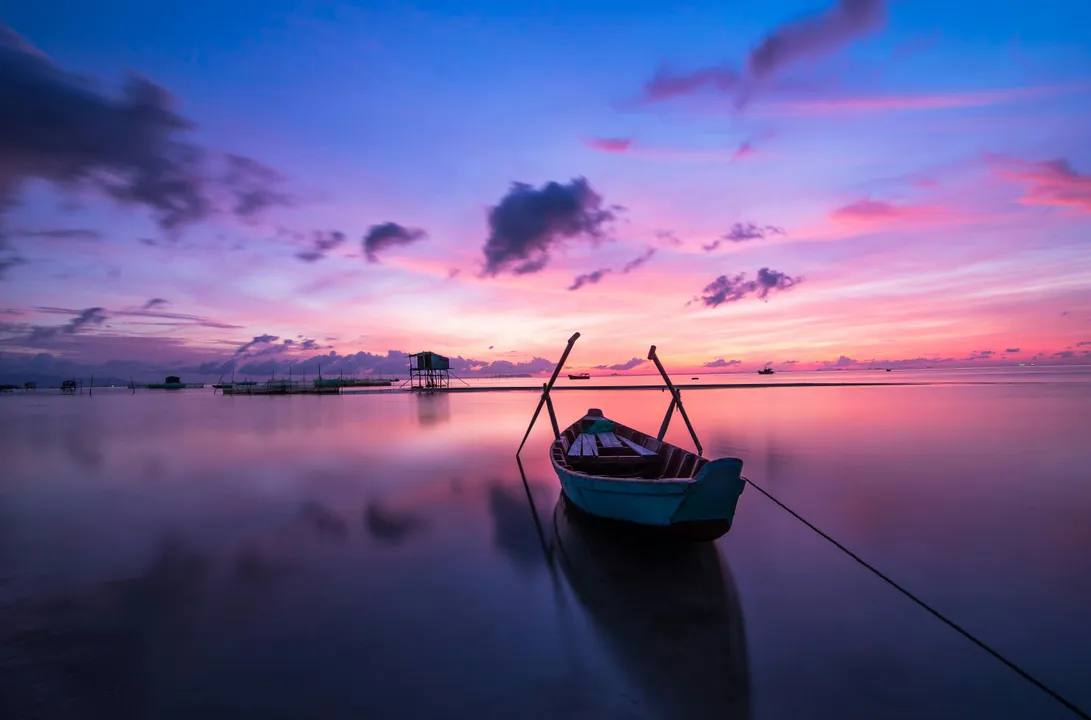 Boat on calm sea at sunset